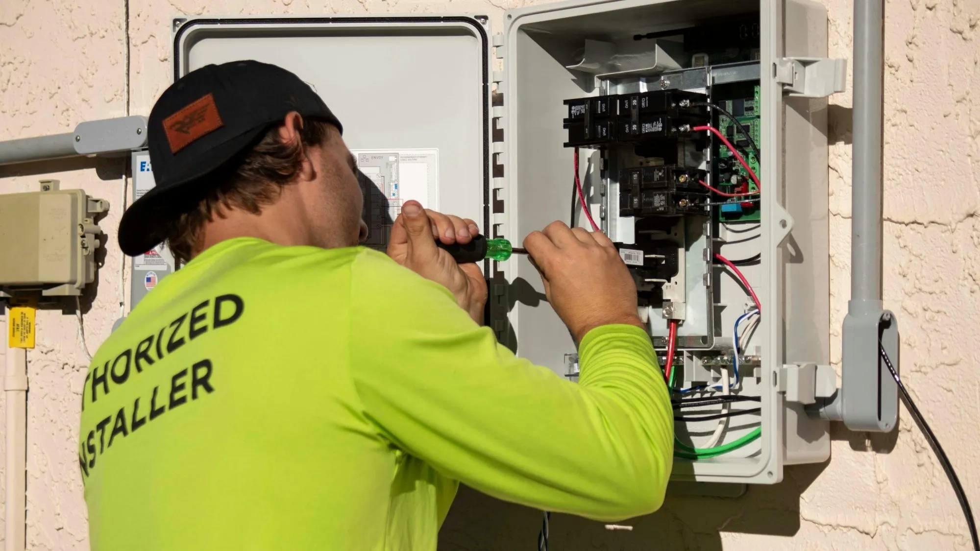 Électricien raccordant un coffret électrique extérieur